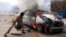 A man tries to extinguish a burning car after it exploded near Hamaerweyne market in Mogadishu, Somalia, July 24, 2013. 