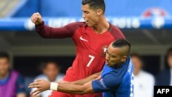 L'attaquant français Dimitri Payet et l'attaquant portugais Cristiano Ronaldo lors du match de football opposant le Portugal et la France à l'Euro 2016 au Stade de France, au nord de Paris, le 10 juillet 2016.