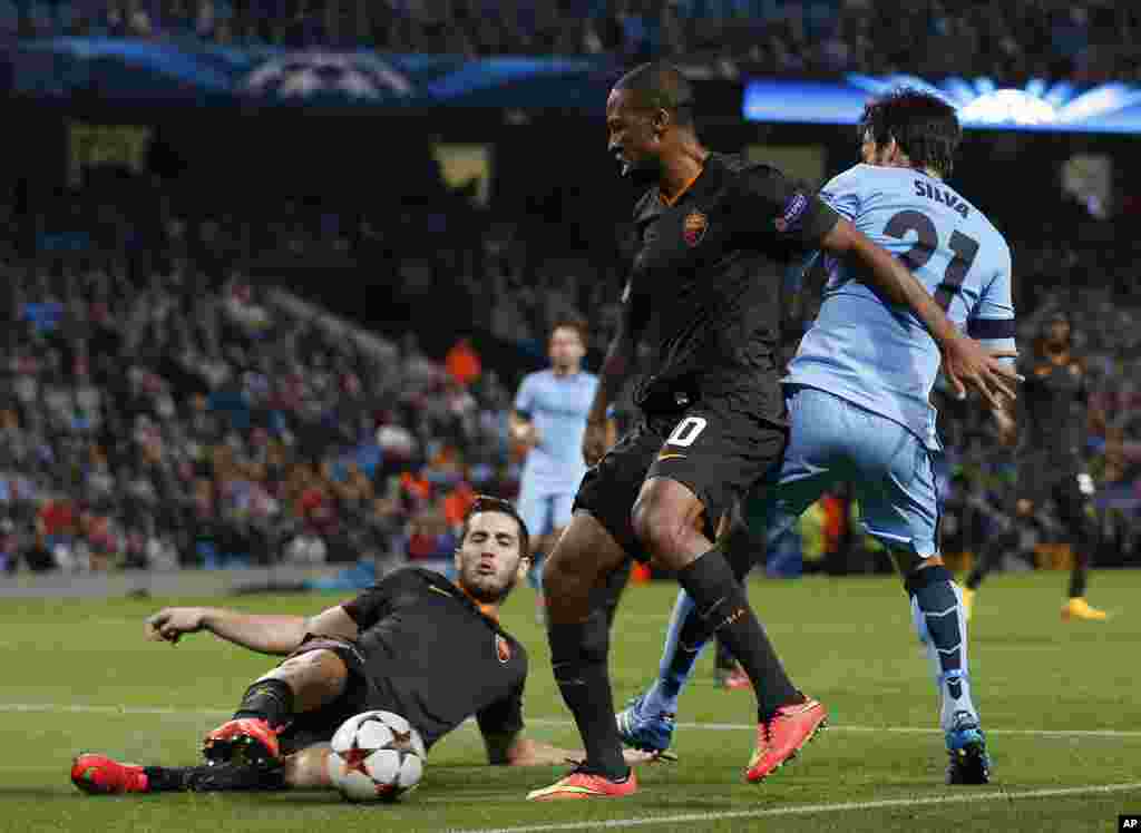 Seydou Keita et son coéquipier Konstantinos Manolas de Roma, à gauche, en lutte pour le ballon contre David Silva de Manchester City lors d&#39;un match de la Champions League entre Manchester City et Roma au Stade Etihad, Manchester, en Angleterre, mardi 30 septembre 2014. 