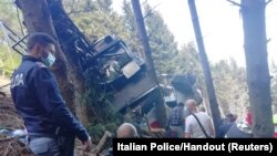 Polisi dan anggota tim SAR terlihat di dekat kereta gantung yang kecelakaan di Stresa, dekat Danau Maggiore, Italia, 23 Mei 2021. (KEPOLISIAN ITALIA/Handout via REUTERS)