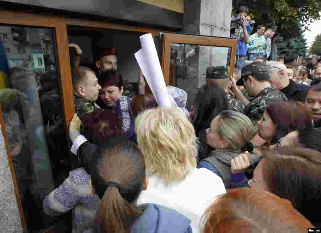 Public activists and relatives of soldiers who they say are surrounded by pro-Russian separatists in eastern Ukraine try to get into the defense ministry building during a protest in Kyiv, Aug. 28, 2014.&nbsp;