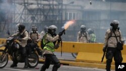 FILE - A police officer fires tear gas against anti-government protesters in Caracas, Venezuela, April 20, 2017. 