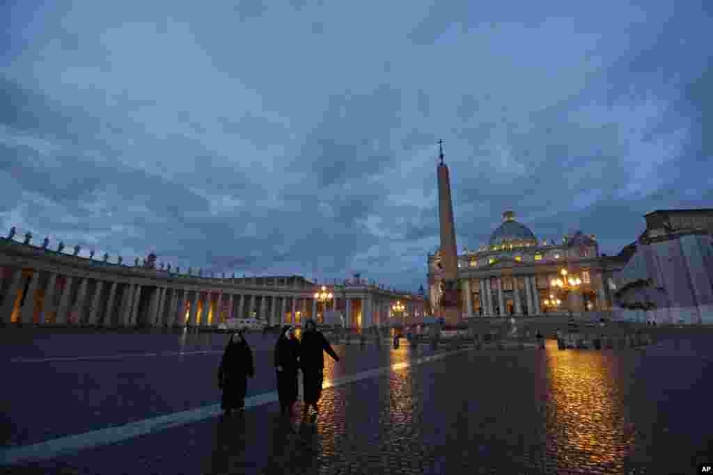 Nuns walk in St. Peter's Square at the Vatican, early Tuesday, Feb. 12, 2013