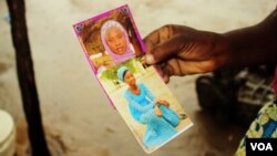 Esther Yakubu tient une photo de sa fille, Dorcas Yakubu, enlevée par les islamistes à Chibok au Nigeria. (VOA / C.Oduah)