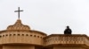 Seorang anggota keamanan berjaga di atas sebuah gereja selama misa pada Malam Natal di gereja Mar Shimoni di kota Bartella, timur Mosul, Irak, 24 Desember 2016. (Foto: Reuters)