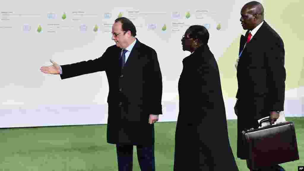 Le président Robert Mugabe du Zimbabwe est accueilli par son homologue français François Hollande, à gauche, à son arrivée à la COP21, au Bourget, 30 novembre 2015.&nbsp;