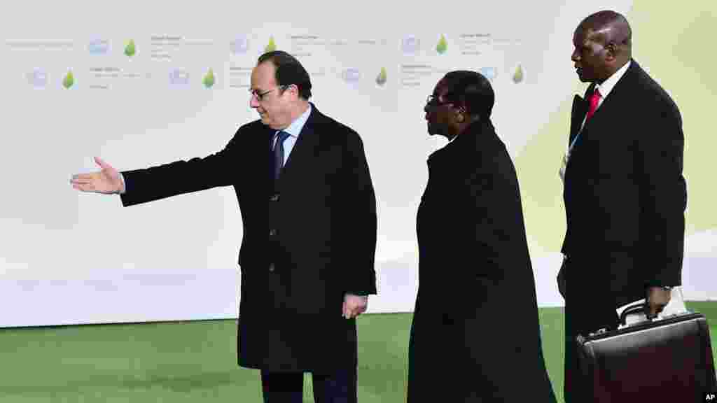 Zimbabwe&#39;s President Robert Mugabe is greeted by French President Francois Hollande, left, as he arrives for the COP21, United Nations Climate Change Conference, in Le Bourget, outside Paris, Monday, Nov. 30, 2015.