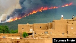 Pueblo tribal members watch the Encebado Fire on Taos Pueblo land in New Mexico, July, 2003. The fire, sparked by lightening, burned 5,000 acres near the Pueblo, leading to subsequent flooding and erosion when rain finally fell. Photo by Ignacio Peralta,