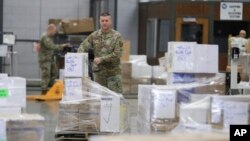 FILE - An Indiana National Guardsman lines up pallets of medical supplies in Indianapolis, March 26, 2020.