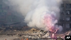 Smoke continues to rise hours after two explosions at a warehouse in Tianjin, China, August 12. 