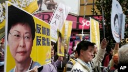 Protesters raise placards and banner during a rally against Hong Kong's former Chief Secretary Carrie Lam in Hong Kong, Feb. 5, 2017. 