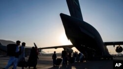 U.S. Air Force airmen guide evacuees aboard a U.S. Air Force C-17 Globemaster III at Hamid Karzai International Airport in Kabul, Afghanistan, Aug. 24, 2021, in this image provided by the U.S. Air Force.