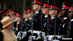 FILE - Britain's Queen Elizabeth smiles with Prince Harry during the Sovereign's Parade at the Royal Military Academy in Sandhurst, southern England April 12, 2006.