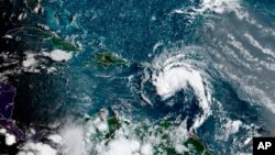 This satellite image provided by the National Oceanic and Atmospheric Administration shows a tropical storm east of Puerto Rico in the Caribbean, at 7:50 a.m. EST, Aug. 10, 2021.