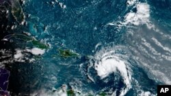 This satellite image provided by the National Oceanic and Atmospheric Administration shows a tropical storm east of Puerto Rico in the Caribbean, at 7:50 a.m. EST, Aug. 10, 2021.