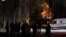 Local residents gather near a residential building as a critical power infrastructure object burns after a Russian drone attack, amid Russia's attack on Ukraine, in Kyiv, Ukraine Dec. 19, 2022. 