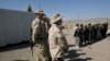 Tentara Australia, bagian dari Pasukan Bantuan Keamanan Internasional (ISAF), berdiri di dekat warga Afghanistan di pangkalan militer Tarin Kowt, Kabul, 17 Februari 2021. (AP/Musadeq Sadeq)