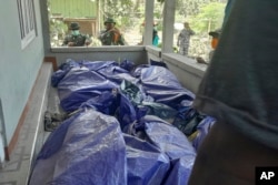 En esta fotografía difundida por la Agencia Nacional de Búsqueda y Rescate de Indonesia, los rescatistas inspeccionan los cuerpos de las víctimas de la erupción del monte Lewotobi Laki-Laki en el este de Flores, Indonesia, el lunes 4 de noviembre de 2024. (BASARNAS vía AP)