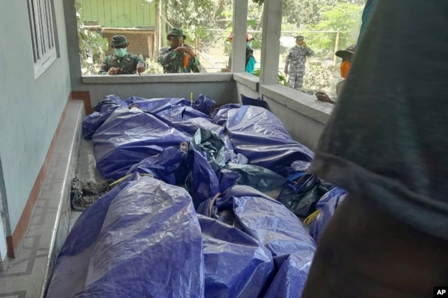 En esta fotografía difundida por la Agencia Nacional de Búsqueda y Rescate de Indonesia, los rescatistas inspeccionan los cuerpos de las víctimas de la erupción del monte Lewotobi Laki-Laki en el este de Flores, Indonesia, el lunes 4 de noviembre de 2024. (BASARNAS vía AP)