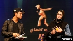 FILE - Zulala Hashimi, 18, right, and Sayed Jamal Mubarez, 23, finalists of the music contest "Afghan Star," rehearse for the show in Kabul, Afghanistan, March 19, 2017.