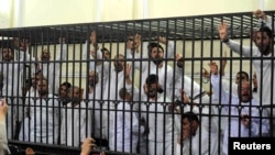 Supporters of former Egyptian president File - Mohamed Morsi, standing trial on charges of violence that broke out in Alexandria last year, react after two fellow supporters were sentenced to death, in a court in Alexandria, March 29, 2014. 