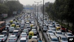 FILE - Vehicles move slowly at a traffic intersection after the end of a two-week experiment to reduce the number of cars to fight pollution in in New Delhi, India, Jan. 16, 2016. 