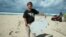 FILE - An undated handout photograph made available June 10, 2016, by Blaine Alain Gibson shows Gibson holding pieces of debris possibly belonging to the missing Malaysian Airlines plane MH370, which were found on Nosy Boraha island, Madagascar.