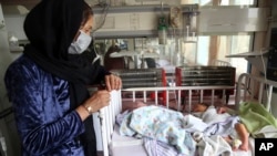 FILE - Babies lie in their beds at the Ataturk Children's Hospital a day after they were rescued following a deadly attack on another maternity hospital, in Kabul, Afghanistan, May 13, 2020. 
