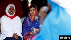 Pakistani Nobel Peace Prize laureate Malala Yousafzai, center, and Somali refugee Rahma Noor attend celebrations to mark Malala's 19th birthday at the Dadaab refugee camp near the Kenya-Somalia border, July 12, 2016.