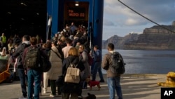 Passengers board a regularly scheduled ferry to Athens' port of Piraeus, after a spike in seismic activity raised concerns about a potentially powerful earthquake in Santorini, southern Greece, Feb. 3, 2025.