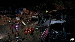 Grabaciones de cámaras de vigilancia mostraban edificios afectados por corrientes de agua intensas y trabajadores limpiando los escombros con retroexcavadoras. Photo: Chinatopix Via AP.