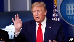 President Donald Trump flips through a stack of papers as he speaks about the coronavirus in the James Brady Press Briefing Room of the White House, in Washington, April 20, 2020.