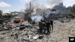 Warga Palestina mengevakuasi jenazah dari lokasi yang terkena serangan roket Israel di Khan Younis, bagian selatan Jalur Gaza, 13 Juli 2024. (Foto: Jehad Alshrafi/AP Photo)