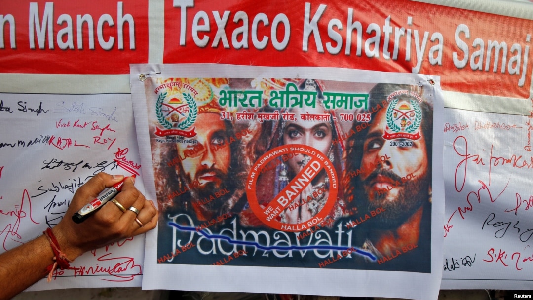 A man signs a banner during a signature campaign as part of a protest against the release of Bollywood movie "Padmavati" in Kolkata, India, Nov. 22, 2017.