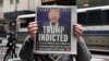 Seseorang berpose di depan gedung Trump Tower dengan halaman muka sebuat surat kabar yang memuat foto mantan Presiden AS Donald Trump di sampul luar setelah Trump didakwa oleh dewan juri di Manhattan, New York, Jumat 31 Maret 2023. 