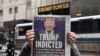 Una persona lee un periódico en Nueva York en el que informan sobre los cargos penales que enfrenta el expresidente Donald Trump. 