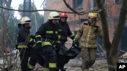 Пожежники несуть тіло загиблого унаслідок російської атаки по лікарні у Дніпрі, 26 травня 2023 р. Фото від ДСНС України через АР