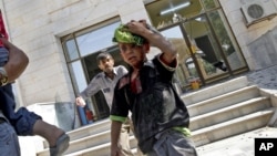 Wounded Syrians evacuate a field hospital after a second air strike in Azaz on the outskirts of Aleppo, Syria, August 15, 2012.