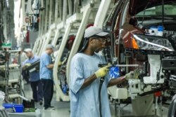 FILE - Workers assemble Volkswagen Passat sedans at the German automaker's plant in Chattanooga, Tenn., June 12, 2013.