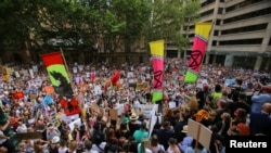 Protesters hold placards during a climate change rally in Sydney, Jan. 10, 2020.