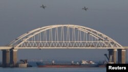 FILE - Russian jet fighters fly over a bridge connecting the Russian mainland with the Crimean Peninsula after three Ukrainian navy vessels were stopped by Russia from entering the Sea of Azov via the Kerch Strait in the Black Sea, Crimea, Nov. 25, 2018.