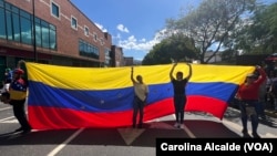 Venezolanas alzan una bandera de su país durante una protesta el 9 de enero de 2025.