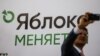 A participant takes a selfie in front of a banner during a congress of the political party Yabloko in Moscow, Russia, April 3, 2021. A banner reads: 'Yabloko is changing.' 