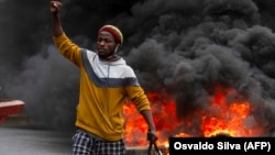 Manifestante em frente a pneus queimados na em protesto contra o Governo em Luanda 24 Outubro 2020