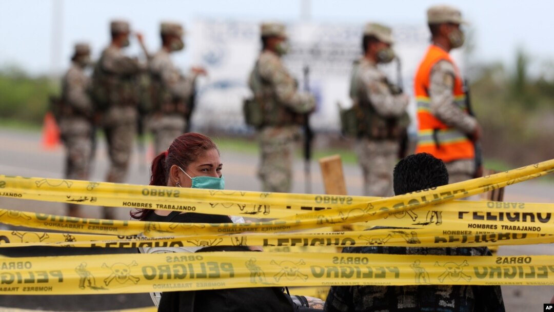 Migrantes venezolanos detenidos esperan en un puesto de control para ser transportados de regreso a Ecuador, en Tumbes, Perú, el 30 de enero de 2021.