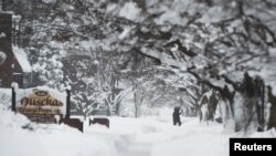 A resident takes a walk on 10th Street after two days of record-breaking snowfall in Erie, Pennsylvania, U.S., Dec. 27, 2017. 