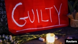 A sign reading "GUILTY" rests next to a candle at Carl Schurz Park after the verdict in the trial of former police officer Derek Chauvin, found guilty of the death of George Floyd, in New York, April 20, 2021. 