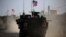 A convoy of U.S. forces armored vehicles drives near the village of Yalanli, on the western outskirts of the northern Syrian city of Manbij, March 5, 2017.