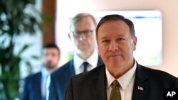 Secretario de Estado de EE.UU., Mike Pompeo, habla con la prensa antes de salir de la Base Aérea al-Bateen en Abu Dhabi, Emiratos Árabes Unidos, el jueves 19 de septiembre de 2019, mientras el representante especial de EE.UU. en Irán, Brian Hook, camina tras él. 