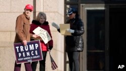 Partidarios de Trump sostienen carteles frente al Centro Judicial de Minnesota, el 2 de noviembre de 2023, en St. Paul, EEUU.